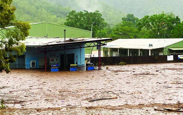 Houses flooded by brown river water.