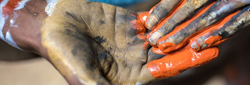 Close up of two hands with mud and paint